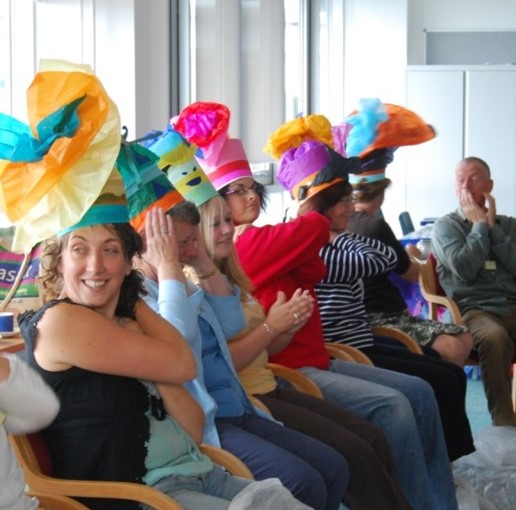 People smiling wearing decorative paper hats